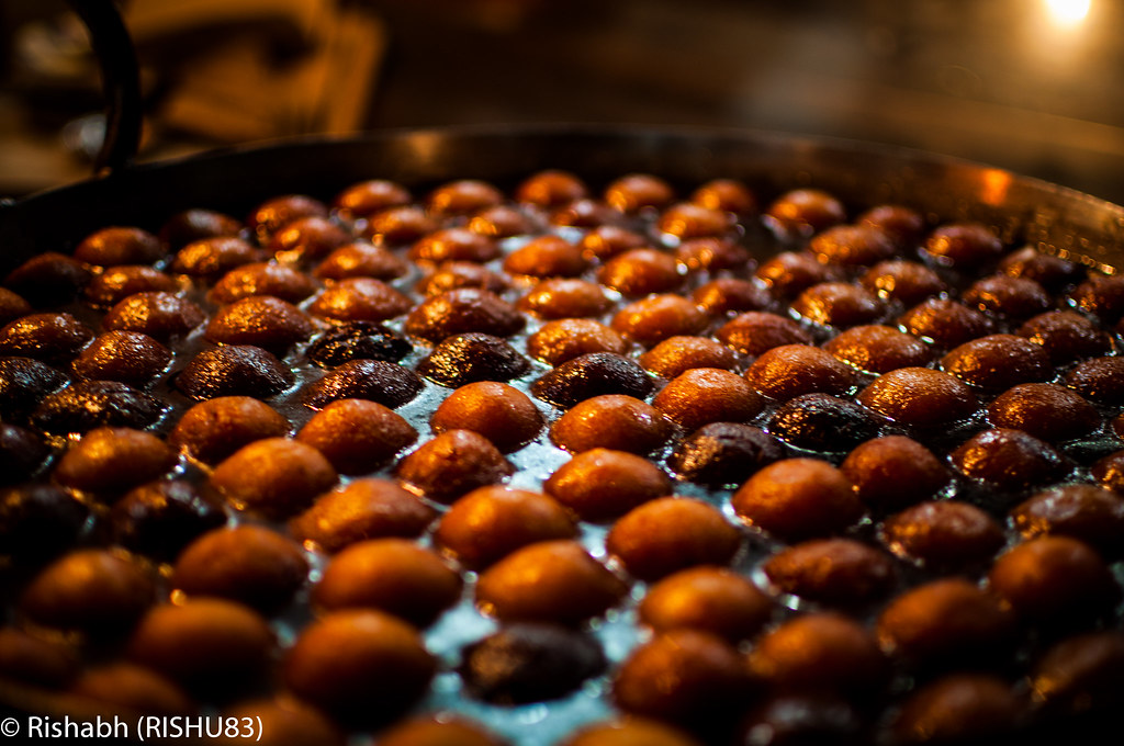 Warm gulab jamun dessert balls soaking in sugar syrup