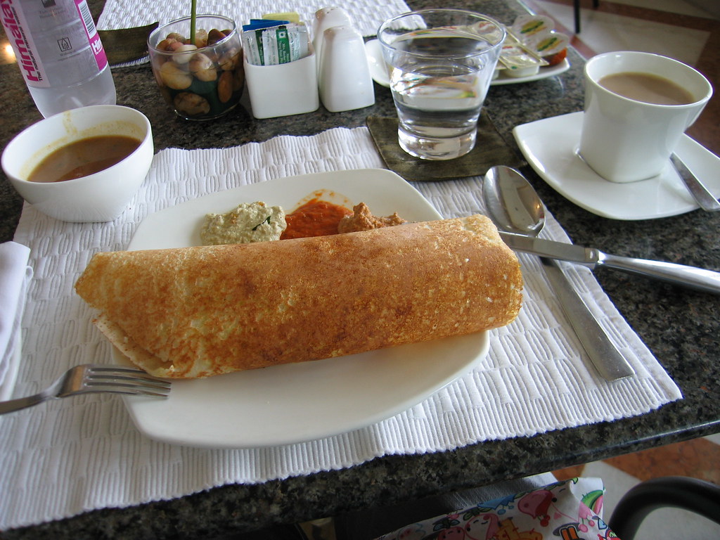 Crisp golden masala dosa rolled with potato filling on a plate